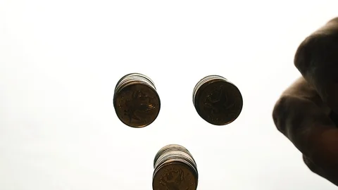 View from below as the hand throws gold coins. Moves them, collects them in the Stock Footage 122610564