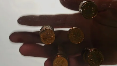 View from below as the hand throws gold coins. Moves them, collects them in the Stock Footage 122610761