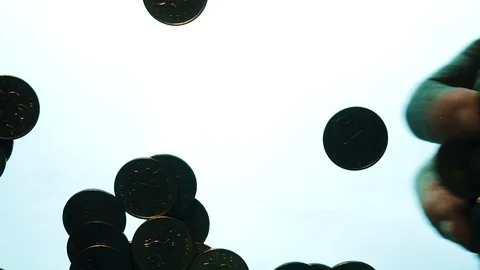 View from below as the hand throws gold coins. Moves them, collects them in the Stock Footage 122611108