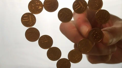 View from below as the hand throws gold coins. Moves them, collects them in the Stock Footage 122615476