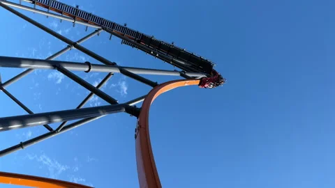 View from below of high roller coaster against the blue sky and laughing people Stock Footage 250199905