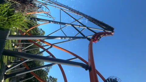 View from below of high roller coaster against the blue sky and laughing people Stock Footage 250199924