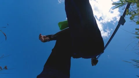 A view from below of a hiker taking a step. background is a blue sky with clouds Stock Footage 248943533