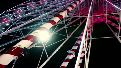 A view from below of a huge ferris wheel with colourful lights in amusement park Stock-Footage 186332494