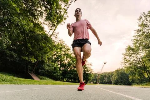 View from below of a long-distance runner training on the athletics track Stock Photos