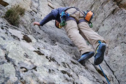View from below of a man climbing a wall Stock Photos