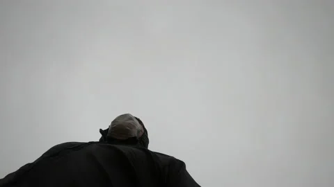 View from below of a man running in his romper and mask on a cloudy day Stock Footage 140768944