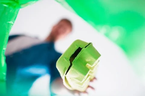 View from below. A man throws cardboard trash into a specially designed basket Stock Photos