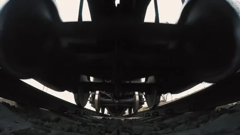 A view from below on the railway and freight train in motion. Close-up of the Stock Footage 74174419