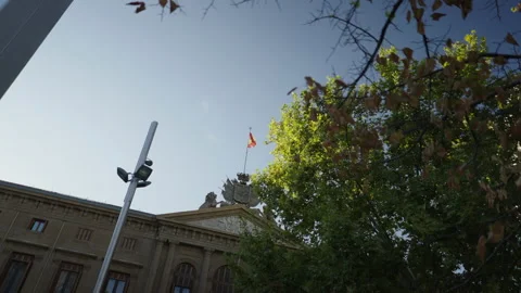 View from below of a Spanish flag flying on an official building Stock Footage 221436143