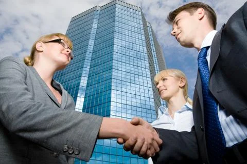 View from below of successful businesspeople handshaking as symbol of collaborat Stock Photos