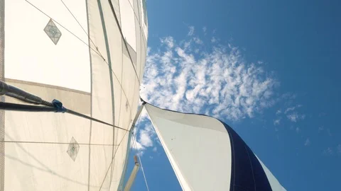 View from below of white and blue yacht sail moving in the wind on the ocean Stock Footage 101640647