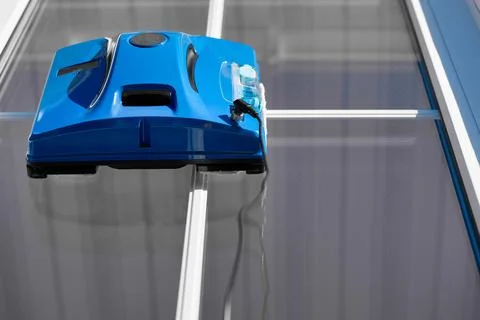 View from below work of automatic robot washer of exterior windows of buildings Stock Photos