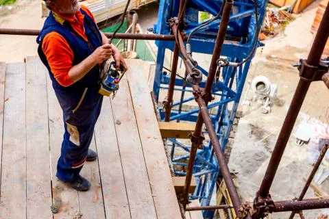 View below on worker who is preparing hooks for cargo Stock Photos
