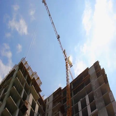 View from below on yellow tower crane on a construction site on bright sunny day Stock Footage 69484310