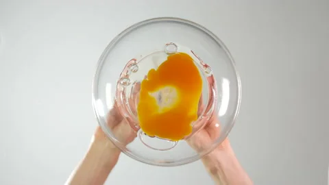 View from beneath of an egg being cracked and poured into a glass bowl Vídeo Stock 159454559