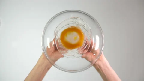 View from beneath of an egg being cracked and poured into a glass bowl Vídeo Stock 159458205