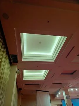 View from beneath a large indoor space with ceiling lights integrated into .. Stock Photos