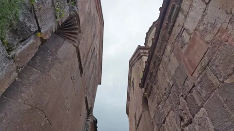 View up between old stone buildings with moss on walls Stock Footage 341737695