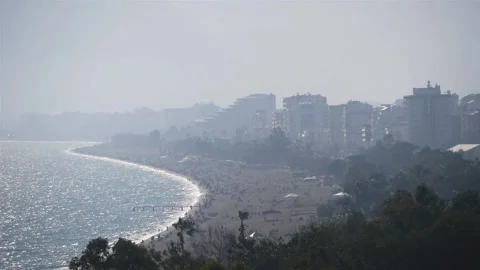 View Of A Big City In Mist On The Seashore With Many People On The Large Beach Stock Footage 217675180