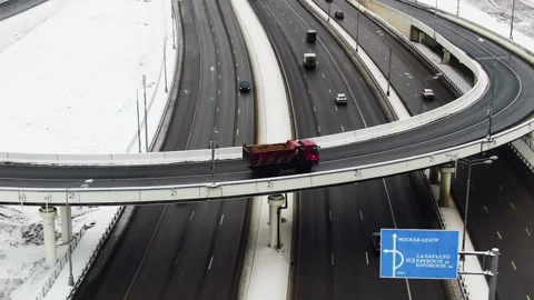 View of the big highway in the forest in winter. A city in the distance. A red Stock Footage 155466383