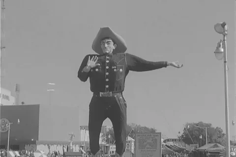 View of Big Tex statue and different amusement rides at state fair - 1963 Stock Footage 105686681