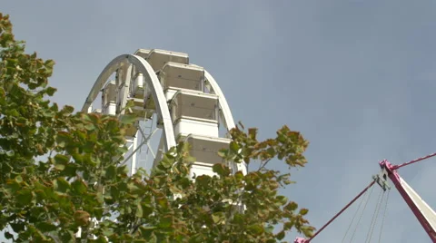 View of the Big Wheel and a air swing carousel spinning in Paris Stock Footage 59973386