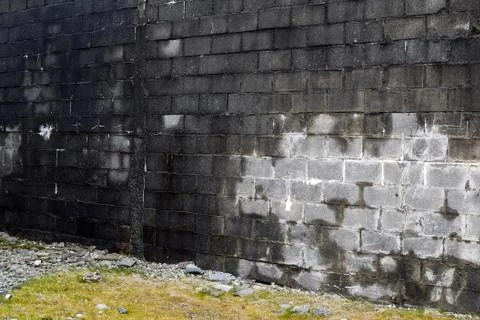 View of a black brick wall at an angle. Background Stock Photos