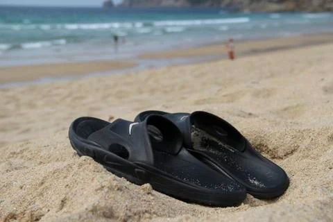 View of black flipflops on sandy beach with ocean waves, Finisterre, Spain Stock-Fotos