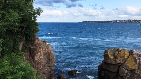A view of a Black sea with bright blue water and a cliff top at summertime Stock Footage 80356434