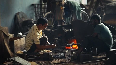 View of blacksmiths forging glowing hot metal in a workshop, Bangladesh. Stock Footage 334950130