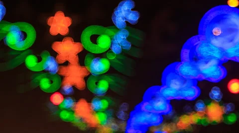 View of blinking colourful figures of lights above city traffic Stock Footage 53776088
