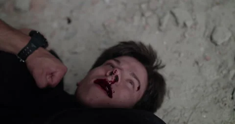 View of bloodied from beating man, lying on the floor under pressure and talking Video stock 131391109