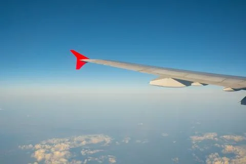 View of the blue clear sky from the height of flight above the clouds from .. Stock Photos