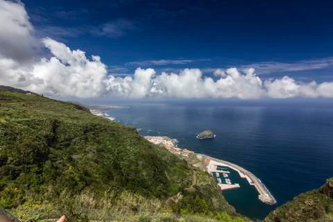 View on blue ocean with white clouds from green hill Stock Photos