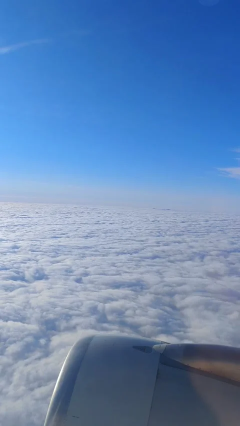View of the blue sky above the clouds from the airplane window. Air travel. Stock Footage 282886151