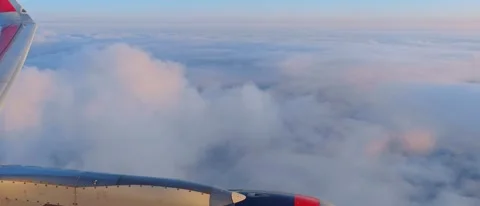 View of the blue sky above the clouds from the airplane window. Air travel. Stock Footage 283567898