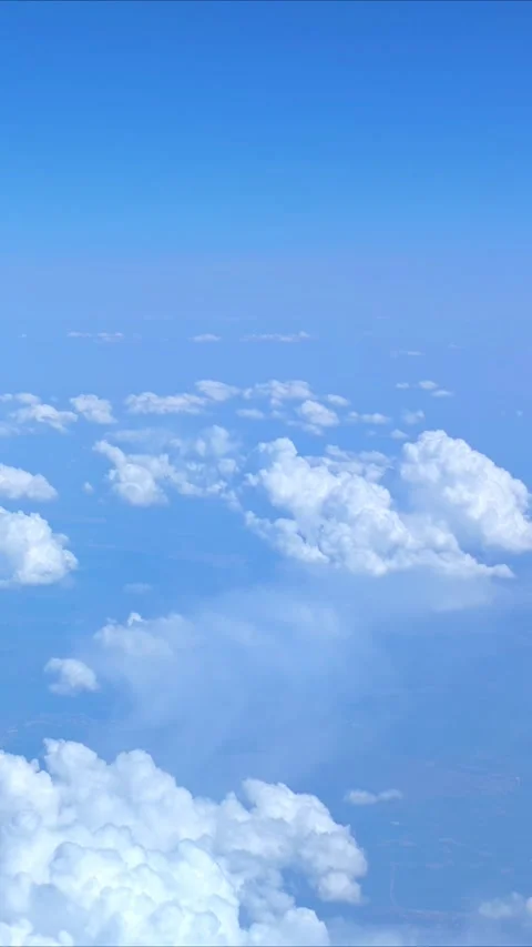 View of the blue sky above the clouds from the airplane window. Air travel. Video stock 309561548