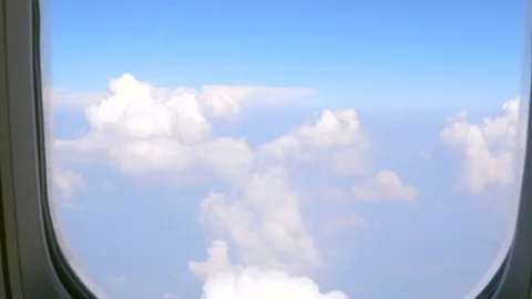 View of blue sky and clouds through an airplane window. Stock Footage 74972054