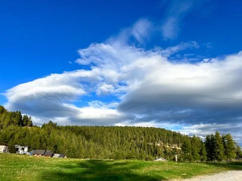 View of blue sky with clouds with mountain forest in the background Stock Photos