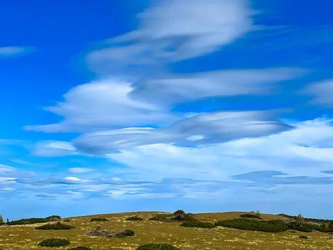 View of a blue sky with clouds over a mountain meadow in autumn Stock Photos