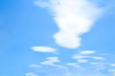 View of the blue sky with ghost-shaped air clouds. Stock Photos