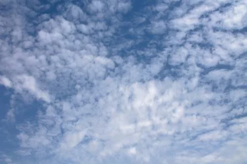 View of a blue sky with a small clouds, different shapes and textured clouds Stock Photos