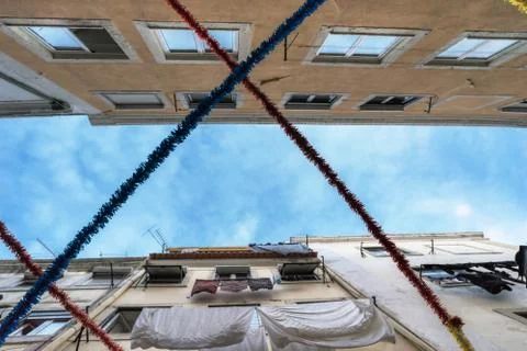 A view of the blue sky through two rows of closely standing apartment buildings Stock Photos