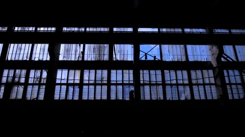 View to blue sky through the windows of old grungy industrial building Stock Footage 88192302