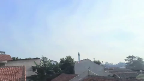 A view of blue sky, white clouds, and brown tile roof in the morning at Jakarta Stock Footage 211793999