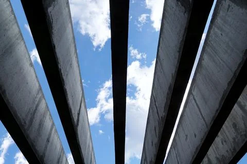 Up view to the blue sky with white clouds through parallel architectural conc 库存照片
