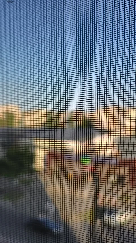 View of a Blurry Cityscape Through a Window Mosquito Net Stock Footage 315107189