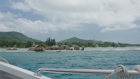 View from a boat approaching La Digue with granite rocks near the shore Vidéo 331506052