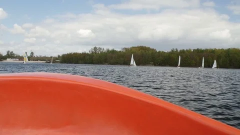 View from boat bow when fast moving over water with regatta in background Stock Footage 75075823